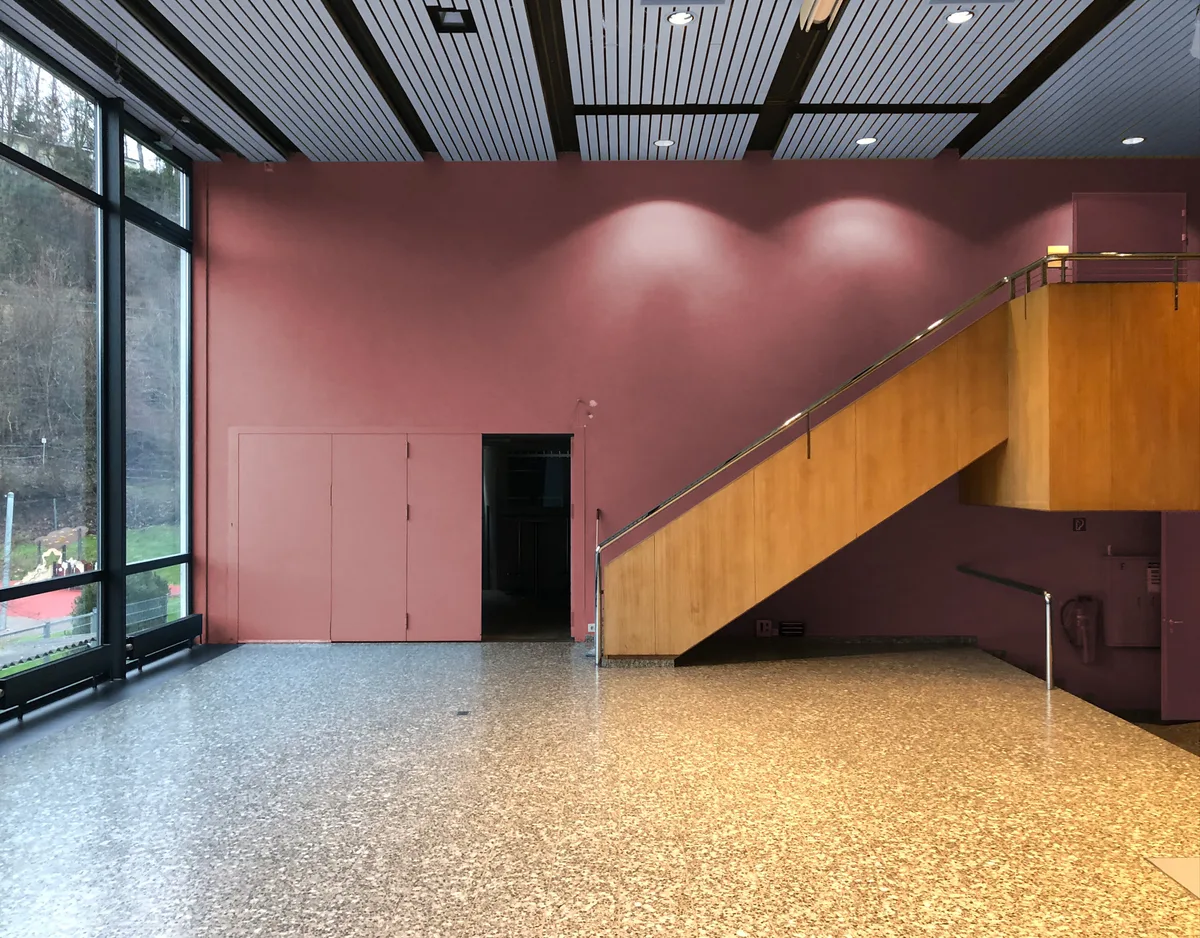 Man sieht eine Fotomontage eines Saals in einem Schulhaus.